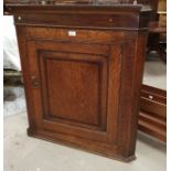 A crossbanded oak corner cupboard with straight front, enclosed by single door