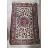 A Persian Isfahan hand knotted rug decorated with floral scrolls, ivory and red ground, 62" x 40"