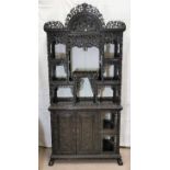 A late 19th century Chinese hardwood full height display cabinet with extensive carving and