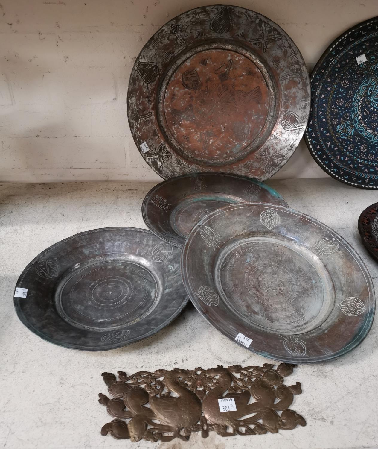 Four Turkish tinned copper dishes and a brass plaque