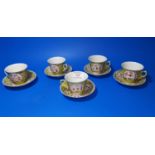 A set of 5 Chinese Famille Jaune cups and saucers with painted decorative panels