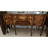 A late 19th/early 20th century serpentine front mahogany sideboard with two cupboards and central d