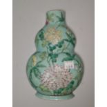 A Chinese porcelain double gourd shaped wall vase decorated with chrysanthemums on pale blue ground,