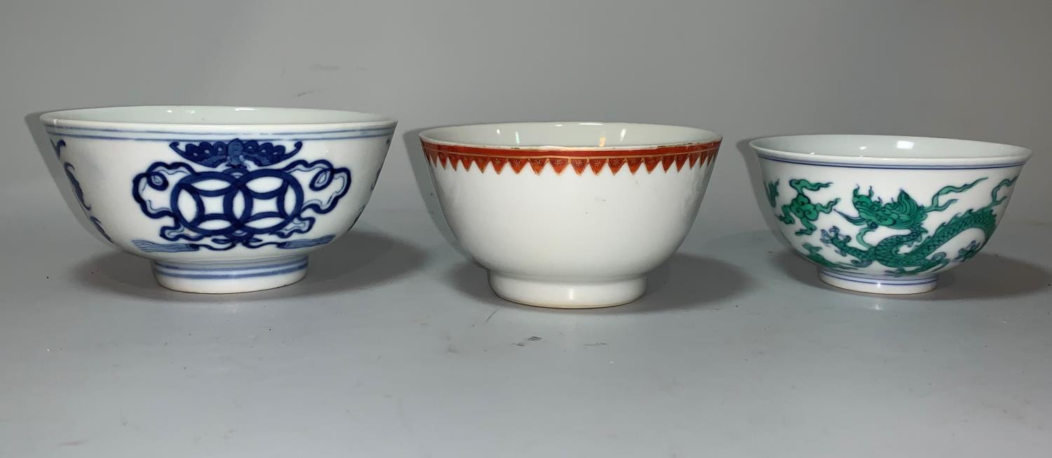 A Chinese porcelain tea bowl decorated with dragons, inscription to interior and 6 character mark to