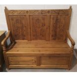 A Victorian style stripped pine carved high back box seat settle