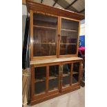 A Victorian pitch pine full height bookcase with twin glazed doors above and below