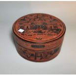 A 19th century Burmese red lacquer circular box and cover, with figural decoration on black