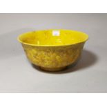 A Chinese yellow glaze bowl with relief decoration of dragonsto the outside, 6 character mark to the