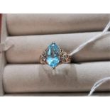A 9 carat gold dress ring set marquise cut pale blue stone flanked by 6 small diamonds