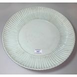 A large Chinese 'Qing' white glazed shallow dish with raised fluted border, underglaze blue seal
