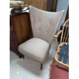 A 1950's semi wing abck low seat armchair reupholstered in brown fabric