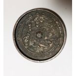 A Chinese cast bronze circular mirror of ancient form, diameter 10 cm