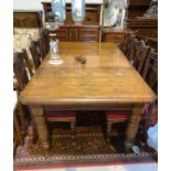 An Edwardian mahogany dining table with wind-out mechanism, on turned reeded legs, 1 spare leaf,