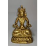 A late 18th / early 19th century Chinese gilt bronze figure of Buddha in the lotus position,