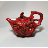 A Chinese coral coloured tea pot decorated with small animals, monkeys etc, with 4 character mark to