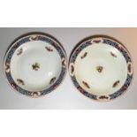 A 19th century pair of Chinese porcelain shallow dishes, blue & white trellis borders decorated with