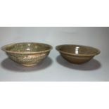 A South East Asian footed bowl with typical brown glaze, 15.5 cm; a similar bowl