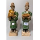 A "Ming" style pair of glazed terracotta figures with presentation gifts, height 9"