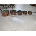A set of copper graduating saucepans
