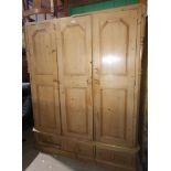 A Victorian style stripped pine triple wardrobe with 3 base drawers