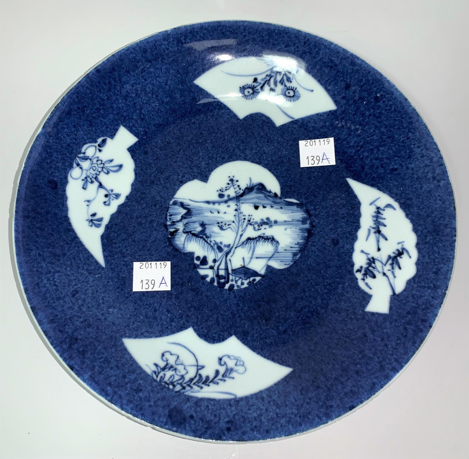 A Chinese Kiangsi blue & white shallow dish decorated with fan and leaf reserve panels against a