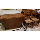 A golden oak heavy drop leaf dining table with oval top, on turned legs, and 4 oak chairs with