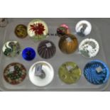 A collection of 13 glass paperweights, including Caithness