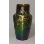 An Art Nouveau iridescent green glass vase in the manner of Loetz, decorated with a spider and web