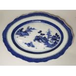 A late 19th century Chinese oval platter, decorated in blue & white with pagodas and mountains in
