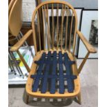 An Ercol pair of lightwood low seat armchairs with hoop backs