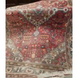 An early/mid 20th century Persian rug, hand knotted, red ground with multiple border and central
