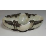A Chinese jade coloured hardstone dish of lobed oval form, decorated with stylized motifs in relief,