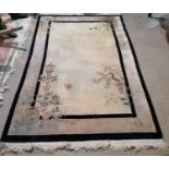 A Chinese rug with cream ground, floral decoration and black border, 101" x 65"