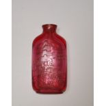 A Chinese ruby coloured glass snuff bottle engraved with landscapes to one side, 28 character text