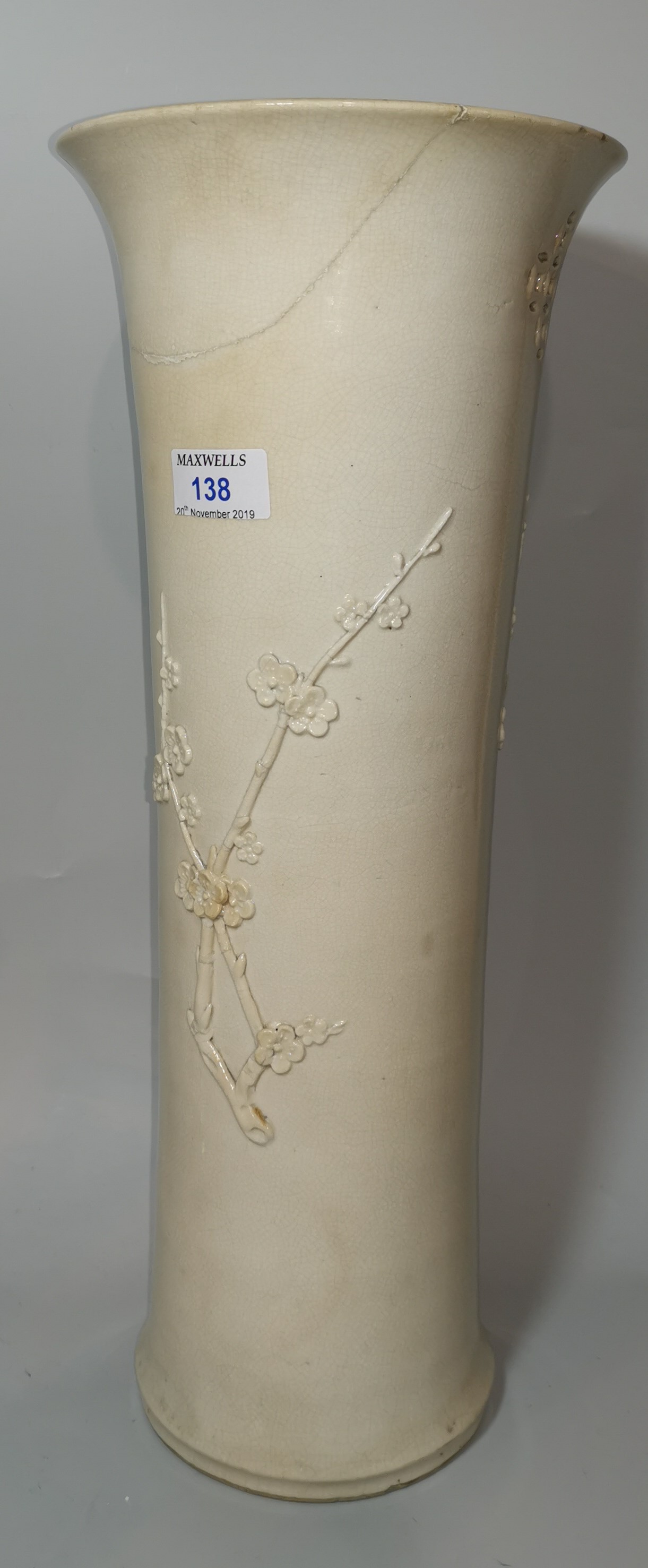 A 19th century blanc de chine cylindrical vase with flared rim, relief prunus branch decoration