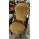 A Victorian walnut low seat chair with carved back, upholstered in gold