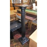 A Victorian ebonised torchère on turned column