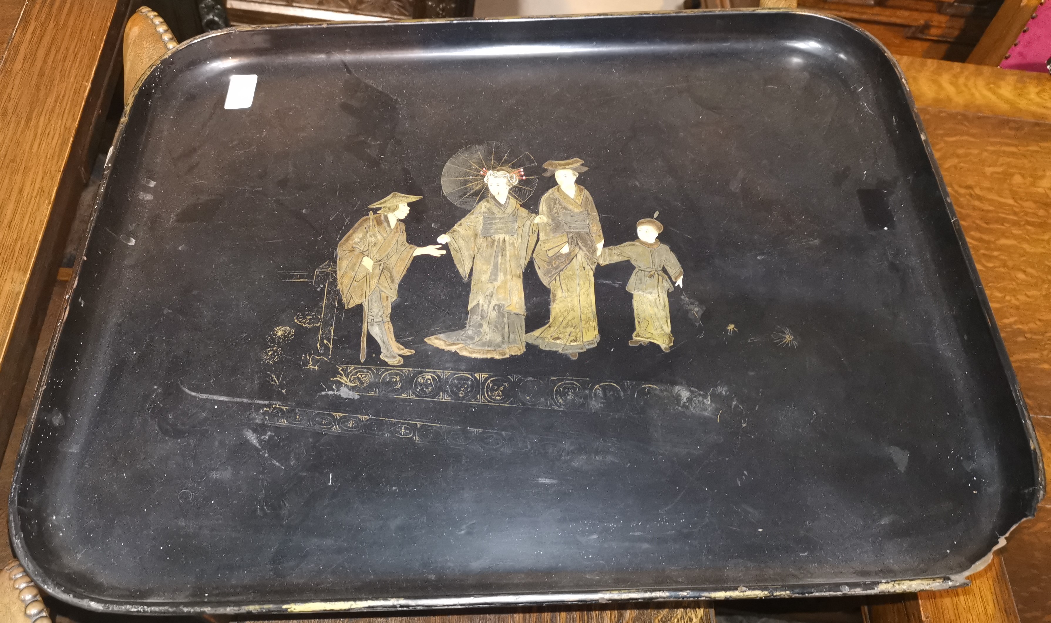An oriental lacquer work tray decorated in gilt with a family, length 24" (1 corner chipped, in need