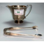 A hallmarked silver milk jug, Birmingham 1940; a pair of hallmarked silver sugar tongs, 1918, 3.1 oz