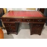 A Georgian style mahogany twin pedestal desk, inset tooled red leather top, fitted 9 drawers, 137