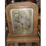 An edwardian oak cased mantel clock with silvered dial and chiming movement