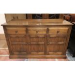 A modern Ercol elm sideboard of 3 cupboards and 3 drawers