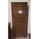 A 1930's golden oak hall robe with carved decoration and panelled door