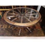A 'ship's wheel' coffee table with circular glass top