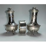 A pair of silver pepper pots and a napkin ring