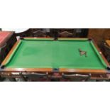 A quarter size snooker table in mahogany with folding trestles, cues, balls and accessories
