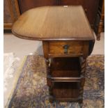 A 1930's oak drop leaf tea trolley on barley twist legs