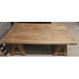 A large rustic coffee table with rectangular top, on trestle base