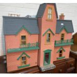 A large impressive doll's house with brick effect walls, central tower and first storey balconies,