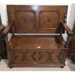 A 1930's oak monks bench with box seat and barley twist armrests